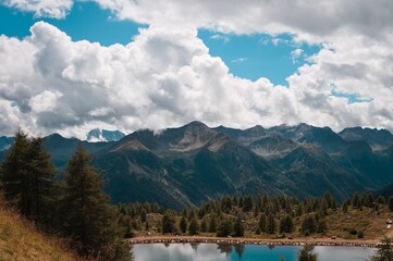 A lake in the Italian Alps with a forest and mountains in background (Trentino, Italy, Europe)
