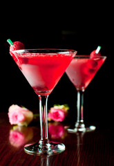 Cosmopolitan Cocktail. Action shot. Alcoholic Drinks made with gin, vodka, rum or whiskey mixed with soda water, fruit juices and garnishes with limes and cherries. Classic American bar drinks.