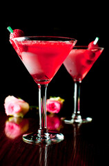 Cosmopolitan Cocktail. Action shot. Alcoholic Drinks made with gin, vodka, rum or whiskey mixed with soda water, fruit juices and garnishes with limes and cherries. Classic American bar drinks.