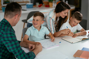 Parents helping the kids with their homework. Litlle boys learning at home..