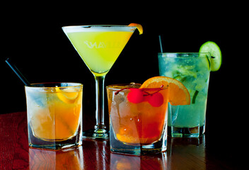 Cocktails. Traditional American drinks made by artisanal bartenders or mixologists in speakeasy & upscale bars or dives or taverns.Cocktails served in chilled cocktail glasses & garnished with fruit.