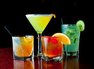 Cocktails. Traditional American drinks made by artisanal bartenders or mixologists in speakeasy & upscale bars or dives or taverns.Cocktails served in chilled cocktail glasses & garnished with fruit.