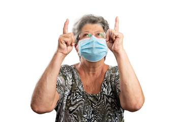 Old woman wearing medical mask pointing fingers at copyspace