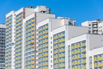 Multi-storey residential complex, and a construction cradle by workers for finishing the external facade.