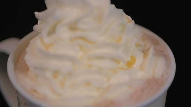 Milk hot chocolate with whipped cream. Cup of hot drink closeup. 4K hand held