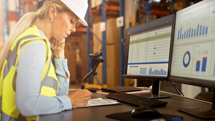 Professional Female Worker Wearing Hard Hat Uses Computer with Inventory Status Checking and...