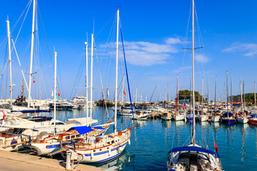 Fototapeta na wymiar White yachts in the sea harbor of Kemer, Antalya province in Turkey. Kemer Marina on the Mediterranean sea