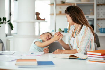 Obraz premium Mother helping her son with homework at home. Little boy learning at home.