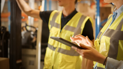 In Warehouse Manager Uses Digital Tablet and Talks with Forklift Driver about Package Delivery....