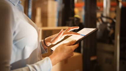 In Warehouse Manager Uses Digital Tablet with App to Check Package Delivery Status with Graphs,...