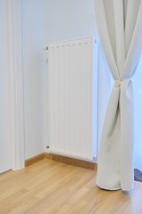 White heating radiator with temperature thermostat in interior of apartment