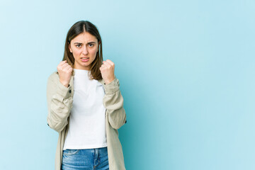 Young caucasian woman upset screaming with tense hands.