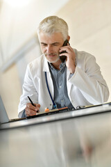 Doctor giving advice to patient by phone - social distancing consultation