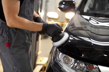 hard-working auto mechanic worker polishing car at automobile repair service, renew service station...
