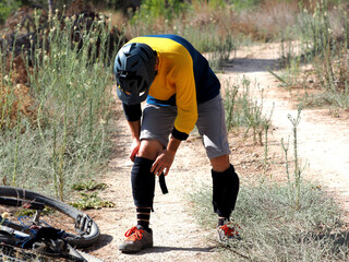 Mountain biker puts on bicycle knee pads