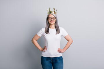 Photo of stunning adorable senior lady wear casual outfit eyeglasses gold crown arms hands waist...