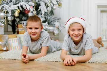 Two boys are lying on the floor near the Christmas tree. Children's friendship. christmas and new year concept. Selective focus