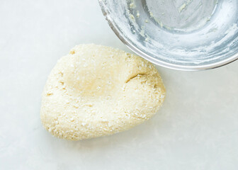 The kneaded dough was laid out from a metal bowl. Top view, no people