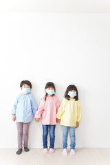 Fototapeta premium マスクをつけて手を繋ぐ幼稚園児