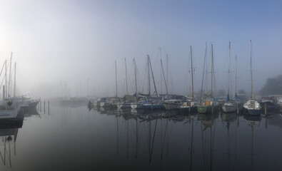 Fototapeta na wymiar Harbor on a misty morning around the Sneekermeer