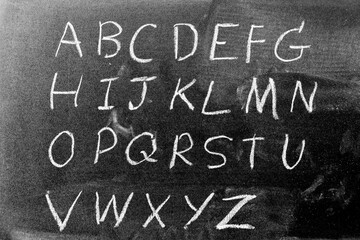 White color chalk hand writing in english capital letter on black board background