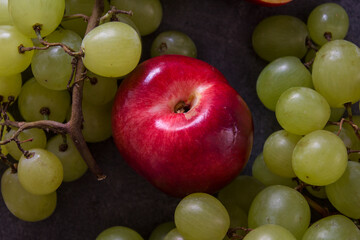 Beautiful fresh fruits on dark grey table: green grapes, nectarines, apricot. Summer fruits top view. 