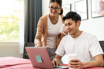 Asian couple working from home with take out food.