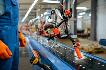 Bicycle factory, worker checks bike assembly line