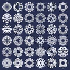 Set of eight pointed circular patterns in intertwined lines style. Thirty six white snowflakes on blue background.