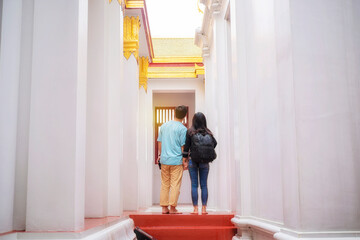 Young Asian tourists enjoy visiting Thai temples during their holidays in Bangkok, Thailand.