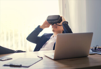 Business man wearing virtual reality goggles in modern coworking office