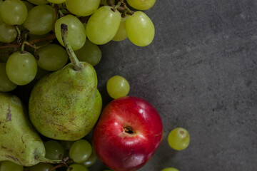 Colorful juicy fruits border.  Fresh summer fruits top view horizontal photo. Dark grey background with copy space. 