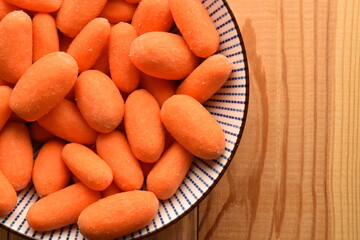 Ripe juicy organic mini carrots, close-up, on a  wooden table.