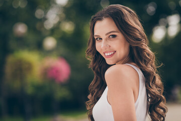 Naklejka premium Profile photo of pretty cute young woman smiling have long curly brunette hair walking around wear white top outdoors