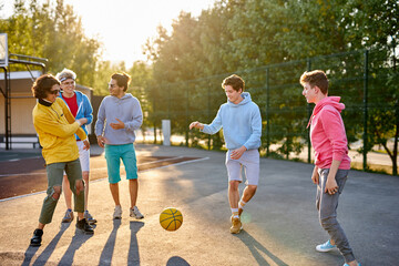 portrait of positive group of young people came to play basketball, in casual wear. caucasian boys...