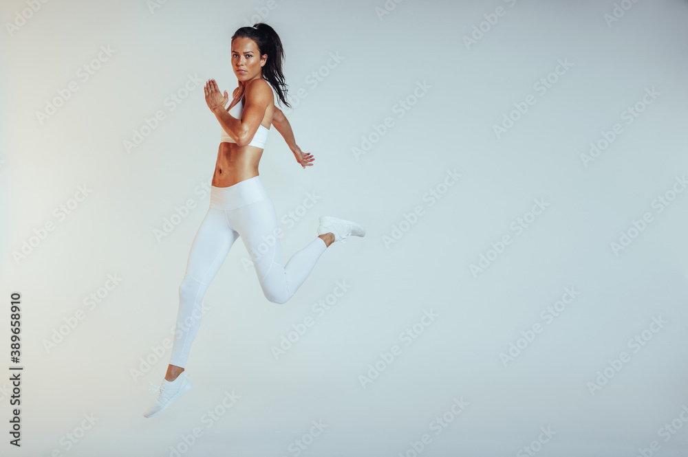 Wall mural side view of female athlete running