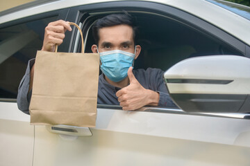 Asian man wear face mask holding shopping bag sitting in car,Mask protect coronavirus covid 19