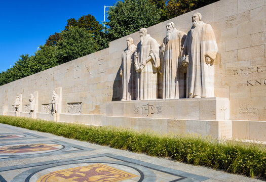 General view of the left half of the Reformation Wall in the Parc des Bastions in Geneva, Switzerland, with the statues to John Calvin and the Calvinism's main proponents, on a sunny day.