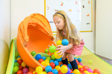 Cute preschool age girl playing with toys during occupational therapy.