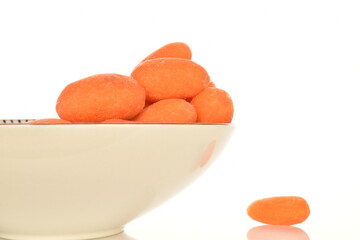 Ripe juicy organic mini carrots, close-up, on a white background.