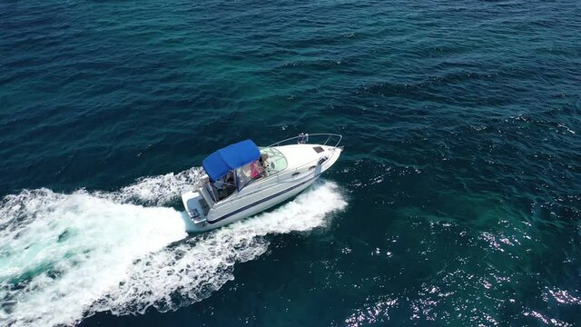 Aerial drone tracking video of speed boat cruising in high speed in deep blue Aegean sea