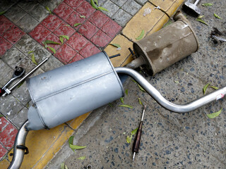 New & old car silencer along with tools.