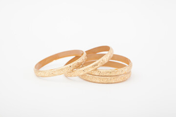 Set of massive golden bracelets on white background with selective focus