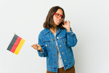 Young latin woman holding a german flag isolated on white background