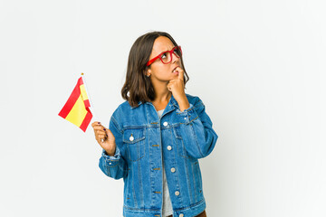 Young spanish woman holding a flag isolated on white background