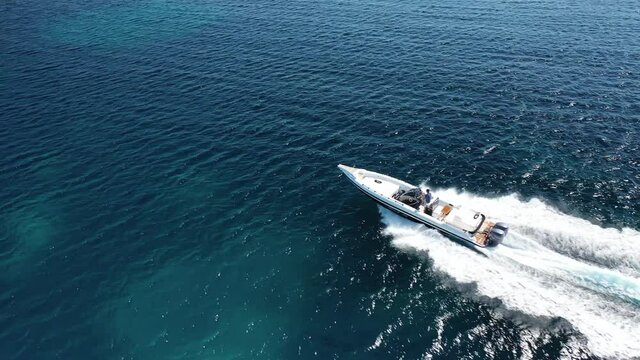Aerial drone video of inflatable rib speed boat cruising open ocean deep blue sea