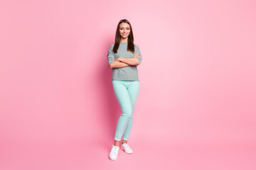 Fototapeta na wymiar Full size photo of positive pretty girl stand crossed arms wear blue pants white sneakers shirt isolated on pink color background