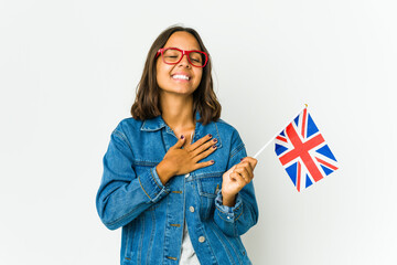 Young latin woman holding a english flag isolated on white background