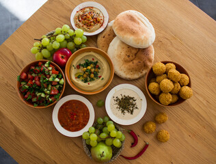 Food of Israel on a table. Top view photo of fresh made hummus, falafels and pita bread. Healthy eating concept. 