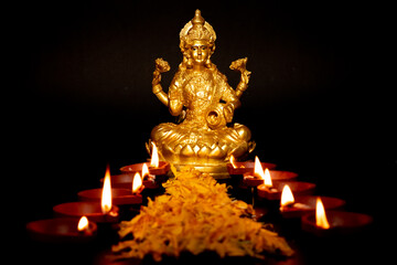 Selective focus of the Mahalakshmi Mahadevi with burning diya lamp. Happy Diwali, Dussehra day or Hindu holiday concept.
